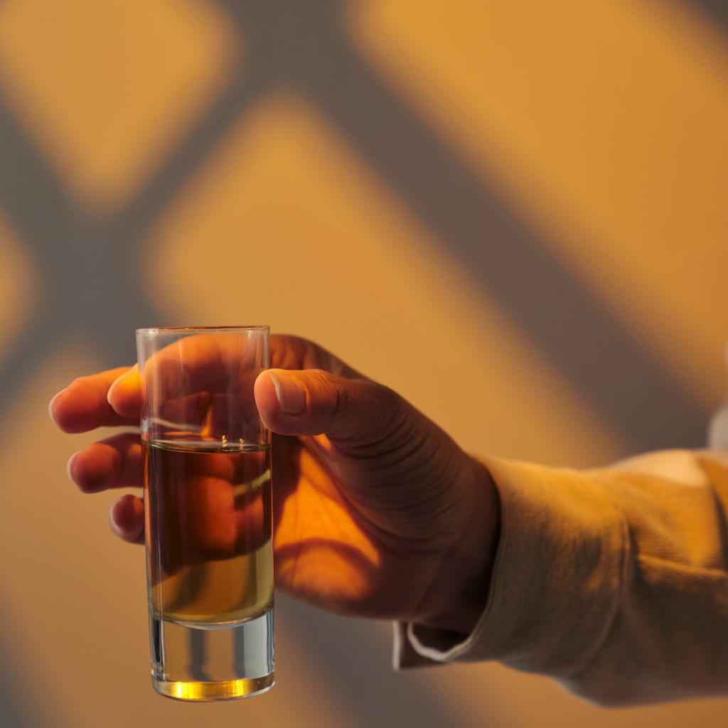 Eine Hand mit einem Glass, ein Symbolbild f&uuml;r Narzissmus und Alkohol