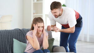 Ein Mann schreit eine Frau an, die sich verzweifelt am Kopf hält, ein Symbolbild dafür, wie gefährlich ein Narzisst nach der Trennung sein kann.